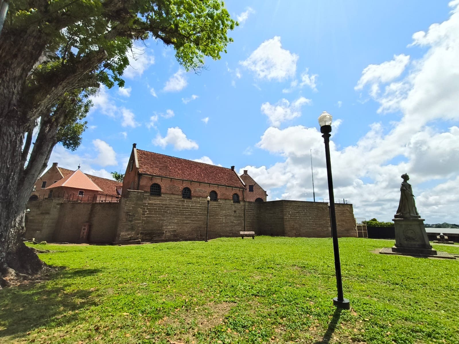 Les murs de brique et les toits rouges du fort Zeelandia, vus depuis la pelouse au bord du fleuve