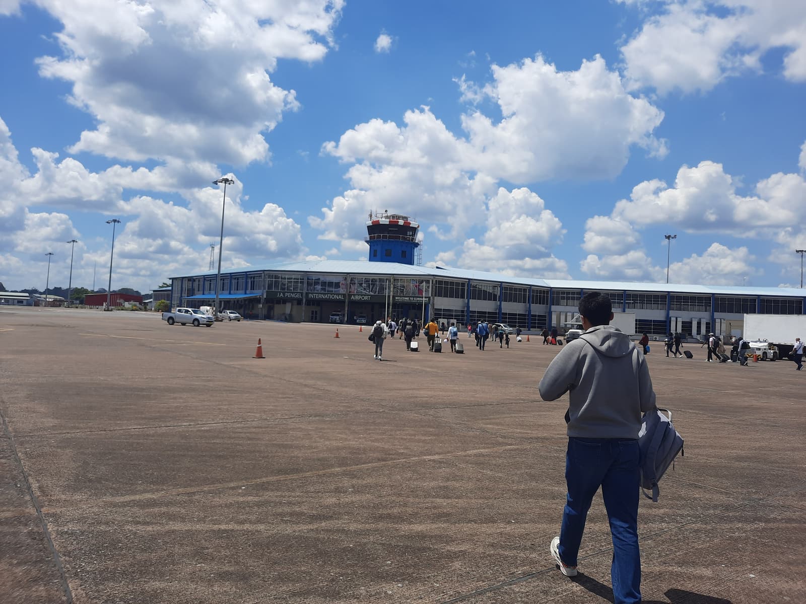 Passagers rejoignant à pied le terminal de l’aéroport international Johan Adolf Pengel